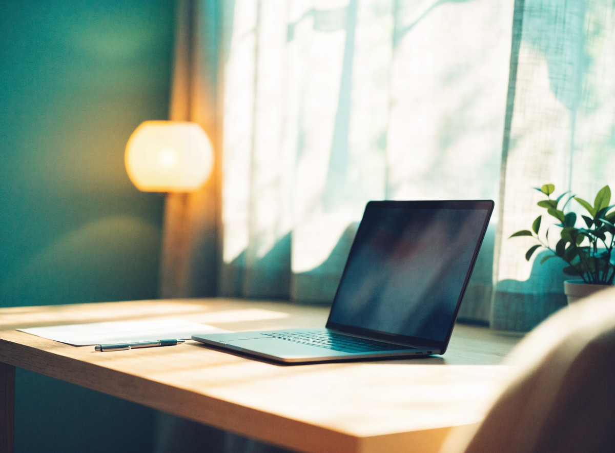 Laptop beside a printed worksheet in a calm home office